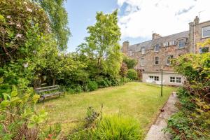 a garden with a bench in front of a building at Hazelton Townhouse - Crail in Crail