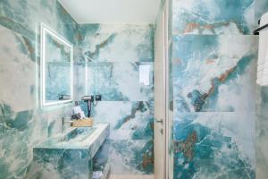 a bathroom with a sink and a mirror at Adessa Villas in Afitos +40 photos