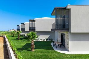 a building with a yard with a table and chairs at Adessa Villas in Afitos