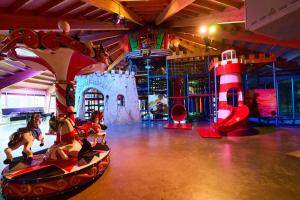 a childrens play area with a playground with toy horses at Kampeerdorp de Zandstuve - Kindvriendelijke Vakantiepark in Rheeze
