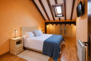 a bedroom with a bed and a television in it at La Senda del Norte in Cabezón de la Sal
