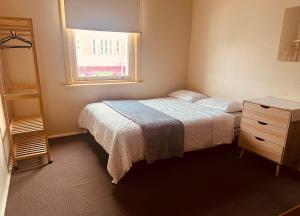 a bedroom with a bed and a dresser and a window at Ararat Hotel in Ararat