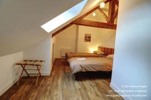 a attic bedroom with two beds and a table at Gîte champêtre LA SUITE Limousin in Saint-Yrieix-la-Perche +34 photos
