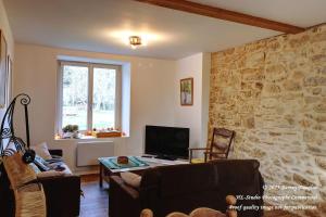 a living room with a stone wall at Gîte champêtre LA SUITE Limousin in Saint-Yrieix-la-Perche