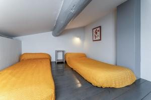 two beds in a room with yellow sheets at Le Soleillant Havre De Paix in L'Isle-sur-la-Sorgue +18 photos