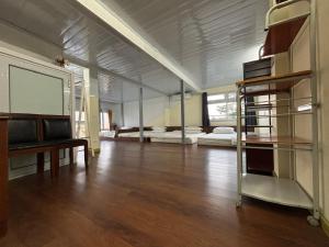 a large room with two beds and a table and a desk at Homestay Chân Mây in Tam Ðảo