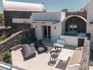 an outdoor patio with chairs and a table at Serenity Collection Suites in Karterados
