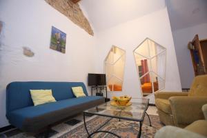 a living room with a blue couch and two mirrors at chez nous - la une in Marseillan
