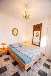 a bedroom with a bed and a mirror and a chandelier at chez nous - la une in Marseillan