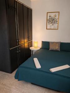 a bedroom with a blue bed with a black closet at Apartman Dona in Petrovac na Moru +6 photos