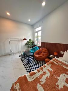 a bedroom with a bed and a couch and a window at Tổ Ấm 25 in Da Thanh