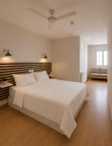 a bedroom with a large white bed with a ceiling at Hotel Peña Pintada by Vivere Stays in Lañada