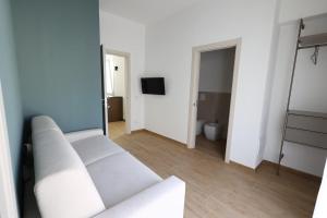 a living room with a white couch and a television at Ferries apartament in Trapani