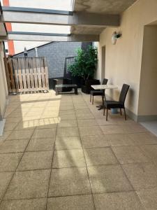 a patio with a table and chairs and a table and a table and chairs at Hôtel des Voyageurs in Changé