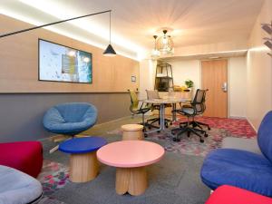 a waiting room with a table and chairs at Novotel Wavre Brussels East in Wavre