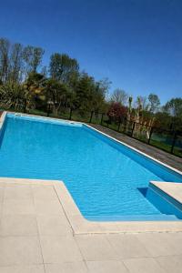 a large blue swimming pool in a yard at chambres nature in La Celle-sous-Gouzon