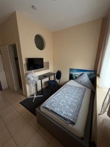 a bedroom with a bed and a desk and a television at Top of Hostel &Serviced Aparts SEBO Pension in Fürth
