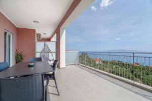 a balcony with a table and chairs and the ocean at Nirvana Homes in Vlachata