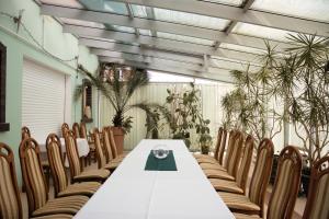 a table and chairs in a room with plants at Pensjonat Korona in Modrzyca