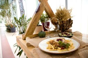 a table with a plate of food and a glass of wine at Pensjonat Korona in Modrzyca