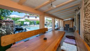 a wooden bench on a patio with a pool at Villa Katarina by Villas Guide in Barban