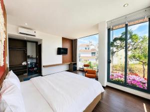 a bedroom with a large white bed and a large window at Arora Home Pleiku in Pleiku +68 photos