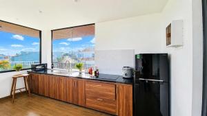 a kitchen with a black refrigerator and a large window at Arora Home Pleiku in Pleiku