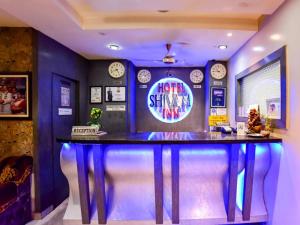a bar in a room with a neon sign at SHIVAM Hotel in Muzaffarpur