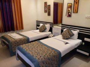 a room with two beds in a hotel room at SHIVAM Hotel in Muzaffarpur