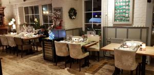 a woman sitting at a table in a restaurant at Hotel Restaurant The Kings Head Inn in Voeren