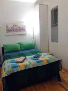1 dormitorio con 1 cama con sábanas verdes y azules en Clear and Cheap, en Bari