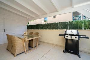 a barbecue on a patio with a table and a grill at Estrella 2 BA Spaniahome in Albir