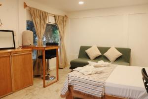 a bedroom with a bed and a couch and a television at Casa Samay in Cozumel