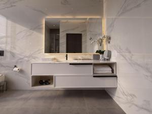 a white bathroom with a sink and a mirror at Villa 72 RAK in Ras al Khaimah