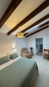 a bedroom with a large bed and a chair at Casa Rural Maria Bargiela in A Picaraña