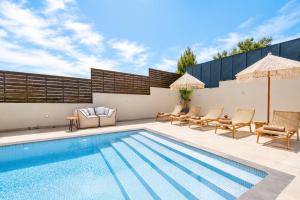 a swimming pool with lounge chairs and a swimming pool at Interni Villa by A&D Properties in Porto Rafti +10 photos