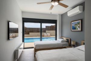 a bedroom with two beds and a swimming pool at Interni Villa by A&D Properties in Porto Rafti