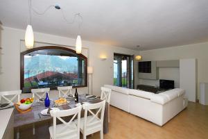 eine Küche und ein Wohnzimmer mit einem Tisch und einem Sofa in der Unterkunft Villa Aurelia in Plesio