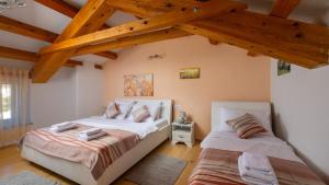 two beds in a room with wooden beams at Villa Katarina by Villas Guide in Barban +34 photos
