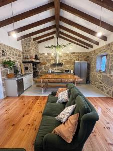 a living room with a green couch and a table at Casa Rural Maria Bargiela in A Picaraña