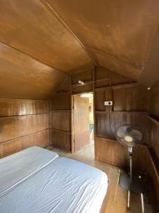 a small bedroom with a bed and a desk in it at Lemon Grass Chalets in Kampong Pasir Panjang
