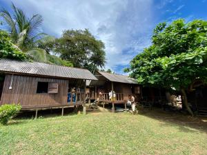 a group of people standing in front of a house at Lemon Grass Chalets in Kampong Pasir Panjang