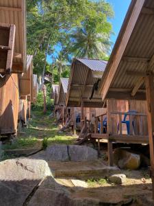 a row of wooden huts in a row at Lemon Grass Chalets in Kampong Pasir Panjang