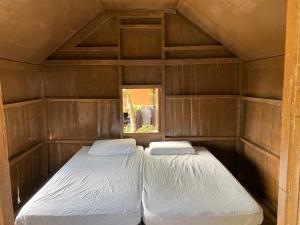 two twin beds in a small room with at Lemon Grass Chalets in Kampong Pasir Panjang