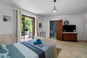 a bedroom with a bed and a tv in it at Chambres D'hôtes - Le Mas Du Rocher in Hyères +44 photos