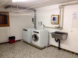 eine Waschküche mit einer Waschmaschine und einem Waschbecken in der Unterkunft Studio Castor Zermatt in Zermatt