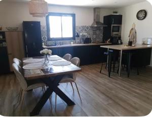 a kitchen with a table and chairs in a kitchen at Belle villa à la mer in Sérignan