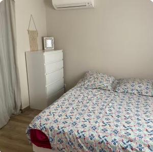 a bedroom with a bed and a dresser at Belle villa à la mer in Sérignan