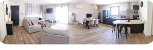 a living room with white furniture and a kitchen at Belle villa à la mer in Sérignan
