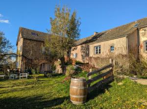 an old building with a barrel in front of it at Saisonnée - Gîtes de Charme en Aveyron in Centrès +50 photos